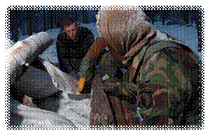 Airmen of the United States Air Force construct a survival shelter during Arctic Survival Training in Alaska.